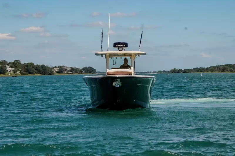 Slide: The Image of 2017 Scout 300 LXF boat cruising on clear blue water under a sunny sky. - 2