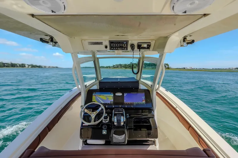 Slide: The Image of 2017 Scout 300 LXF boat dashboard with navigation screens on open water. - 23
