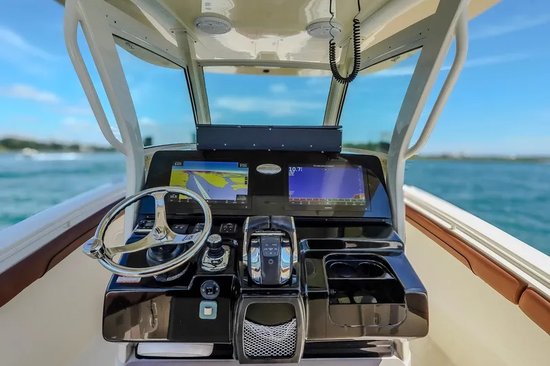 Slide: The Image of 2017 Scout 300 LXF boat dashboard with navigation screens and steering wheel. - 24