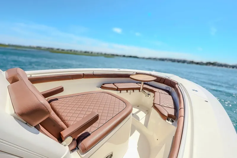 Slide: The Image of 2017 Scout 300 LXF boat interior with luxurious seating and table on open water. - 26