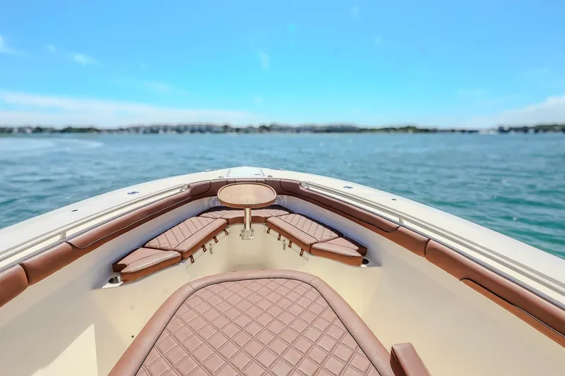Slide: The Image of 2017 Scout 300 LXF boat interior with brown seating, overlooking calm blue waters. - 27