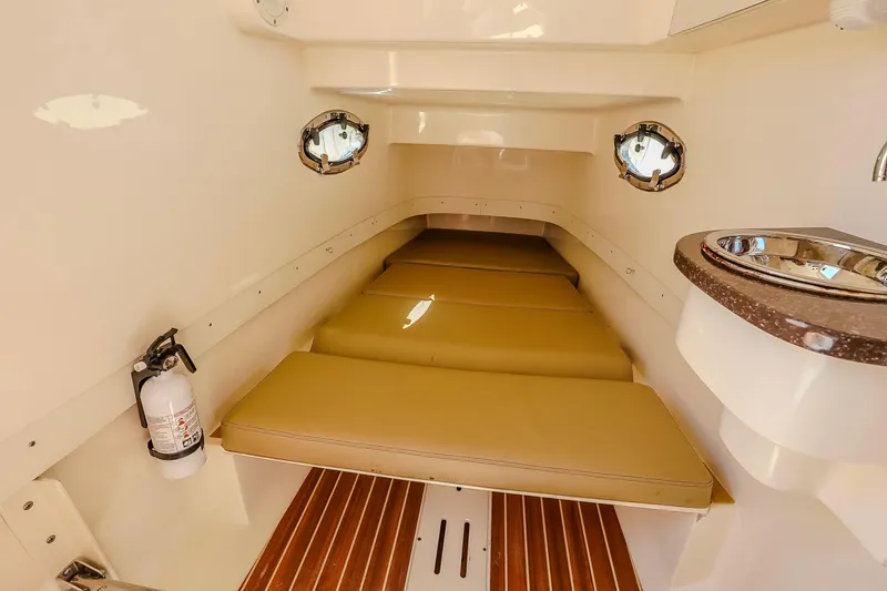 Slide: The Image of 2017 Scout 300 LXF cabin interior with cushioned seating, portholes, and a compact sink. - 31