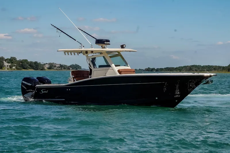 Slide: The Image of 2017 Scout 300 LXF boat cruising on clear blue water under a sunny sky. - 5