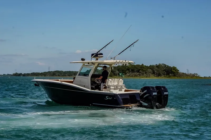 Slide: The Image of 2017 Scout 300 LXF boat cruising on a sunny day with dual engines. - 9