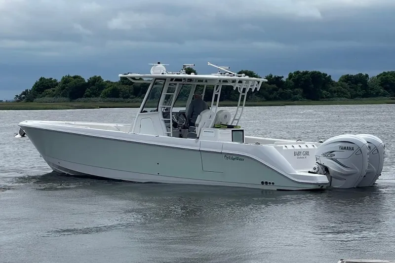 Slide: The Image of Edgewater 340CC 2020 boat with twin Yamaha engines on a calm waterway. - 10