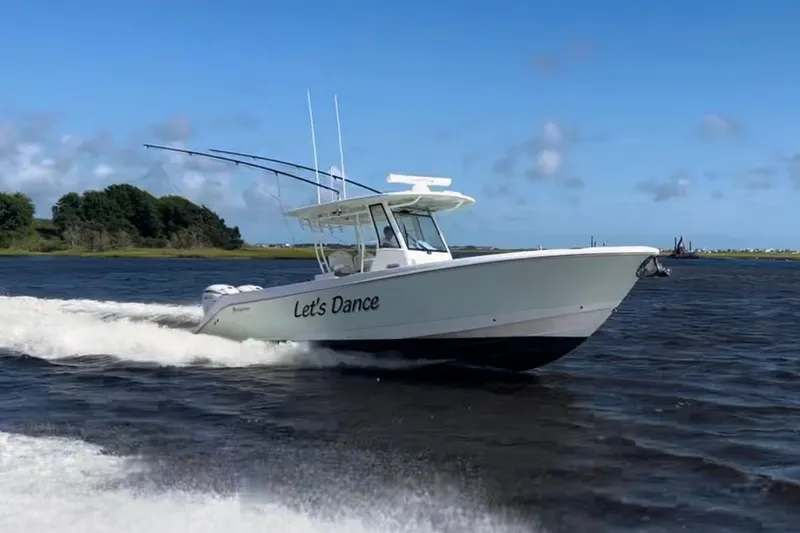 Slide: The Image of Edgewater 340CC 2020 boat named "Let's Dance" cruising on open water. - 2