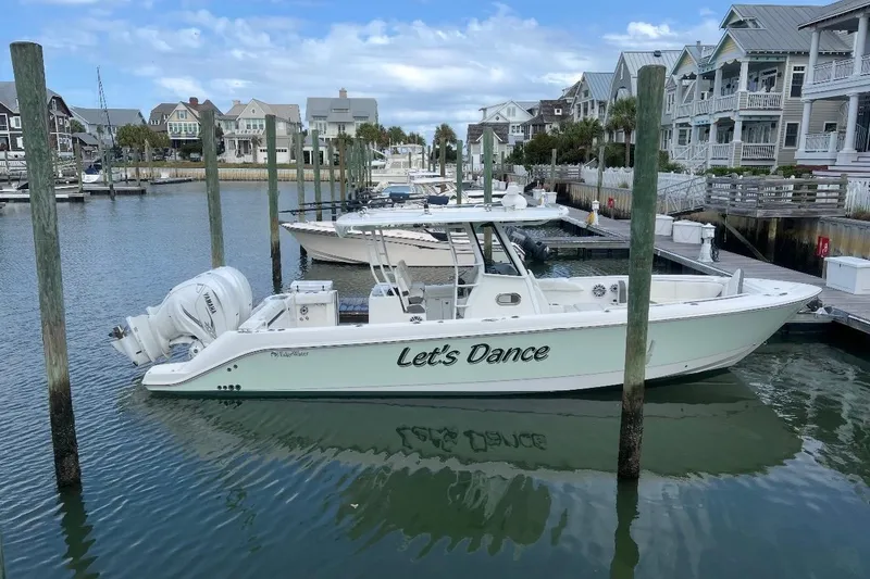 Slide: The Image of 2020 Edgewater 340CC boat named "Let's Dance" docked in a marina. - 3