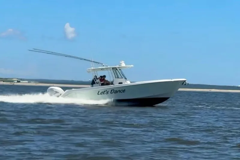 Slide: The Image of 2020 Edgewater 340CC boat named "Let's Dance" cruising on open water. - 4