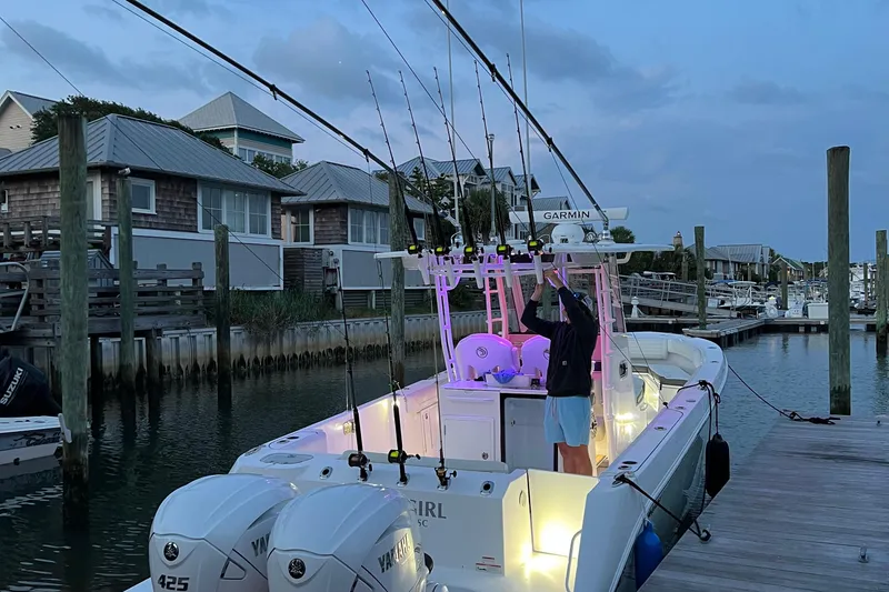 Slide: The Image of 2020 Edgewater 340CC boat docked, equipped with fishing rods and Yamaha engines, at dusk. - 5