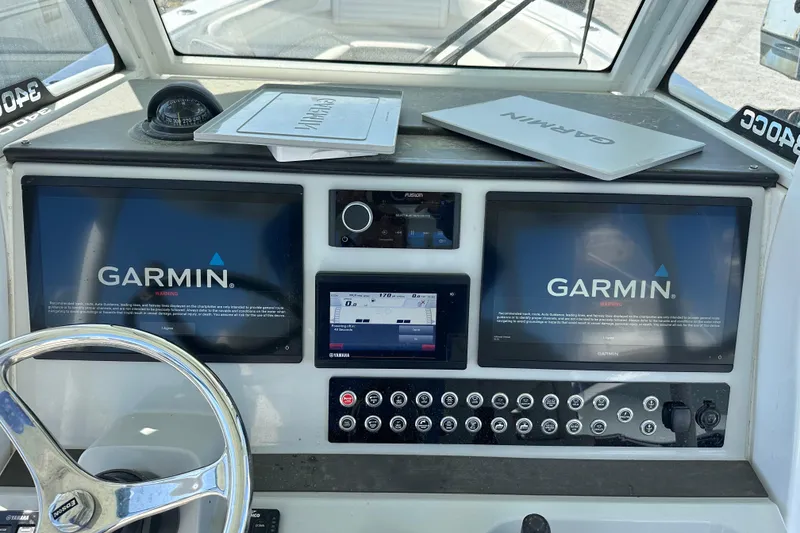 Slide: The Image of Edgewater 340CC 2020 boat dashboard with Garmin navigation displays and controls. - 8