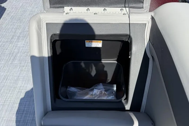 Slide: The Image of Open storage compartment in 2026 Premier 220 SUNSCAPE RL boat, featuring gray upholstery. - 10