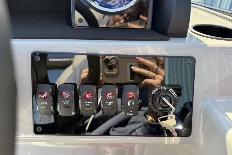 Slide: The Image of Control panel of 2026 Premier 220 SUNSCAPE RL boat with switches and ignition key. - 17