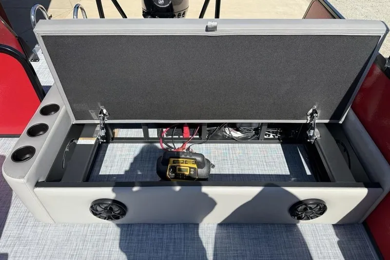 Slide: The Image of Open storage compartment in 2026 Premier 220 SUNSCAPE RL boat with cup holders and speakers. - 23