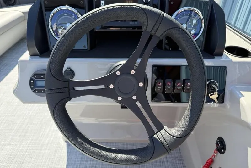 Slide: The Image of Steering wheel of 2026 Premier 220 SUNSCAPE RL boat with dashboard controls. - 7