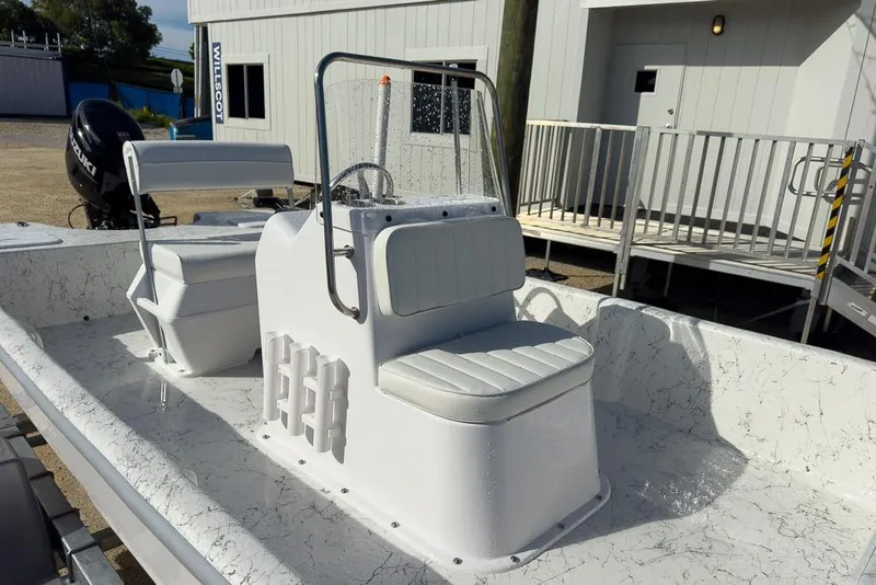 Slide: The Image of 2026 Coastal Skiff 171 boat interior with white seating and steering console. - 10