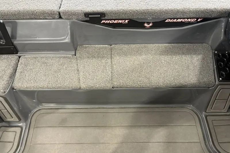 Slide: The Image of 2024 Phoenix 919 Pro XP boat interior with gray carpeted seating and storage compartments. - 13