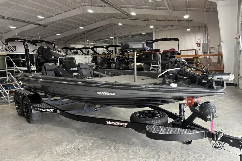Slide: The Image of 2024 Phoenix 919 Pro XP boat in showroom, black exterior, on trailer. - 2