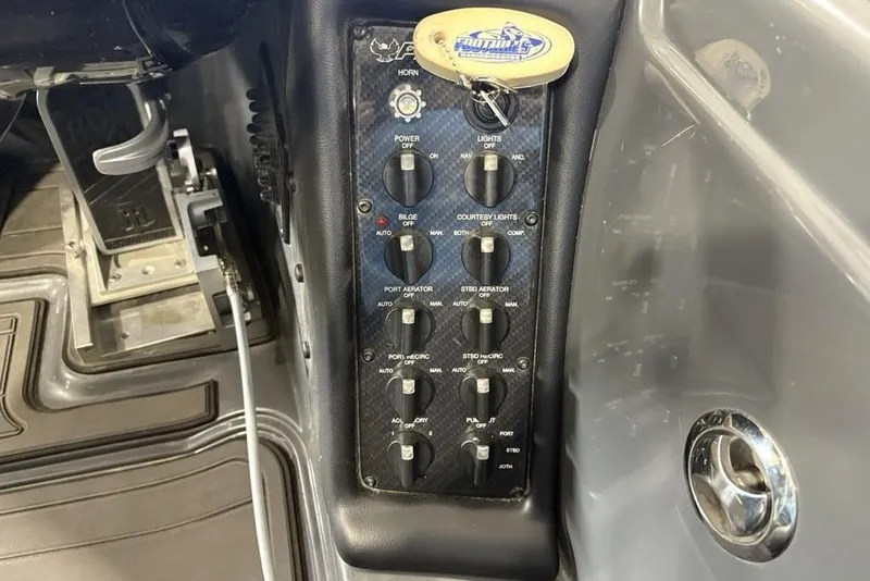 Slide: The Image of Control panel of 2024 Phoenix 919 Pro XP boat with various switches and keychain. - 25