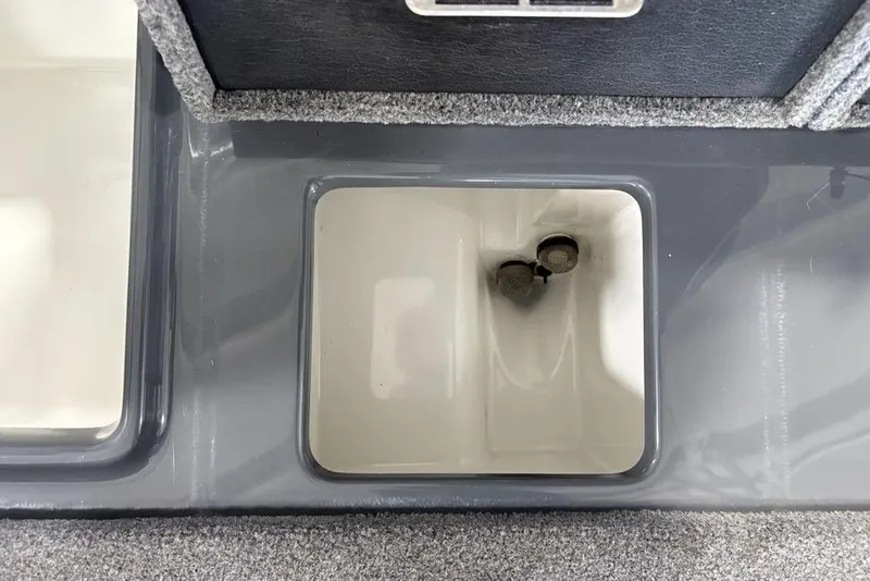 Slide: The Image of 2024 Phoenix 919 Pro XP boat compartment with dual drain plugs. - 38