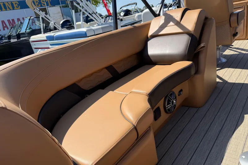 Slide: The Image of Luxurious seating on 2025 SunCatcher Fusion 324RC boat, featuring tan upholstery and integrated speaker. - 7