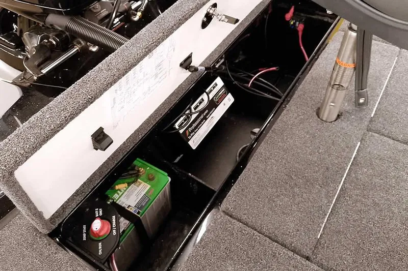 Slide: The Image of 2025 Ranger Z185 Z Pack boat battery compartment with wiring and storage. - 29