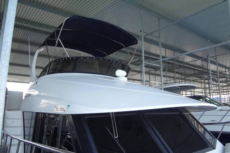 Slide: The Image of 2008 Bluewater 5200 Signature Edition yacht docked under a covered marina. - 11