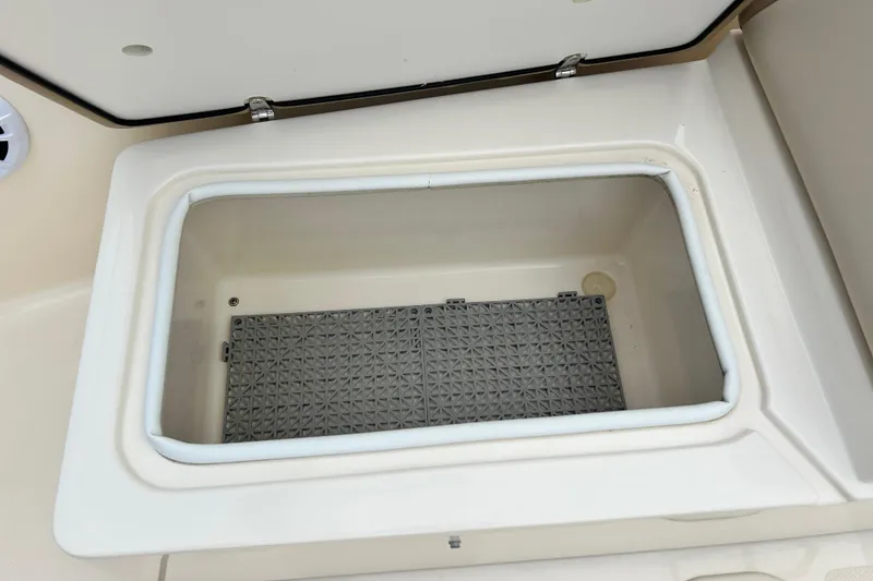 Slide: The Image of 2021 Scout 175 Dorado boat storage compartment with open lid, showcasing interior space. - 22