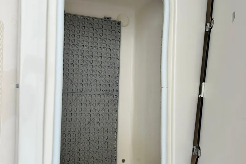 Slide: The Image of 2021 Scout 175 Dorado storage compartment with textured mat and secure latch. - 23