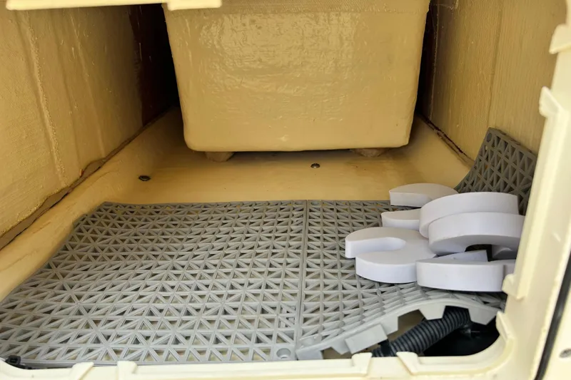 Slide: The Image of Storage compartment of 2021 Scout 175 Dorado boat with gray mat and white foam pieces. - 24