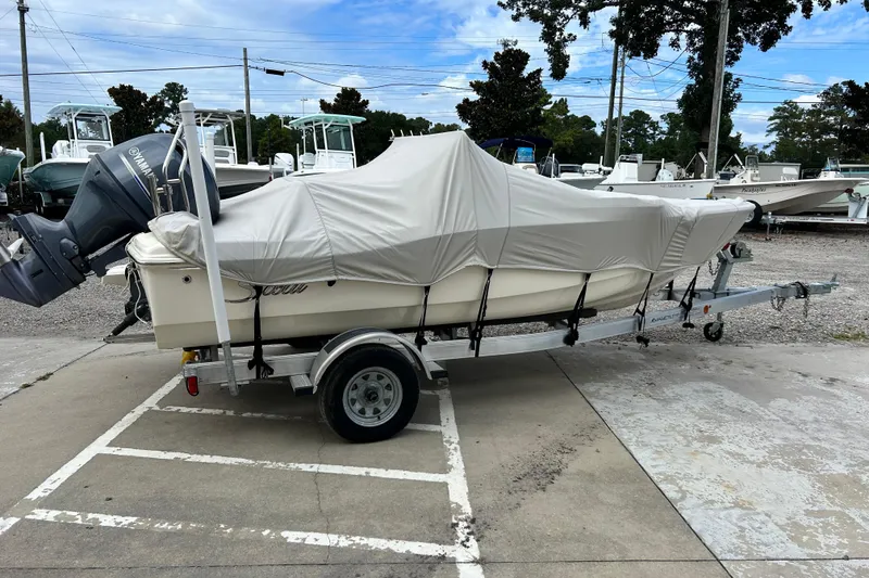 Slide: The Image of 2021 Scout 175 Dorado boat covered on a trailer in a parking lot. - 28