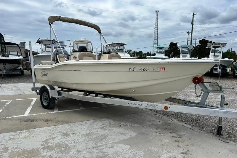 Slide: The Image of 2021 Scout 175 Dorado boat on trailer, parked outdoors under cloudy sky. - 4