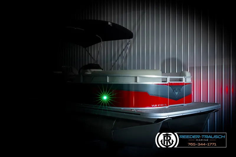 Slide: The Image of 2026 Avalon VLS QL pontoon boat in dimly lit showroom, featuring sleek red and gray design. - 4