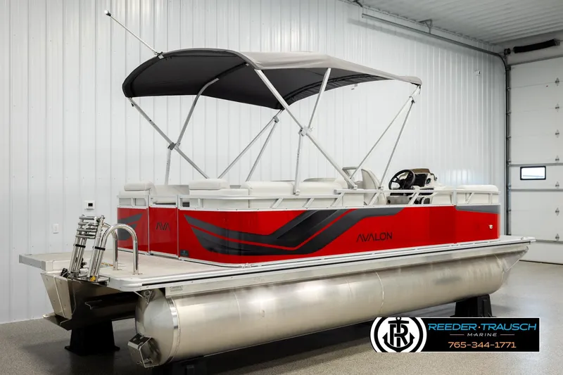Slide: The Image of 2026 Avalon VLS QL pontoon boat with red and black design in a showroom. - 6