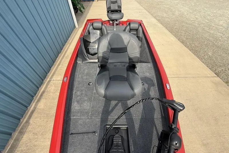 Slide: The Image of 2026 Tracker Pro Team 175 boat with gray seating and red trim, parked on concrete. - 27