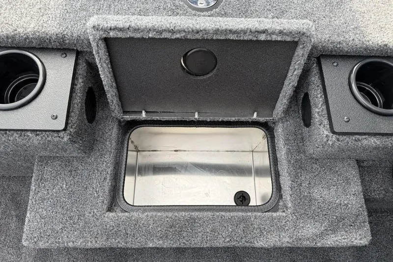 Slide: The Image of 2026 Tracker Pro Team 175 boat storage compartment with cup holders, open lid, and carpeted interior. - 9