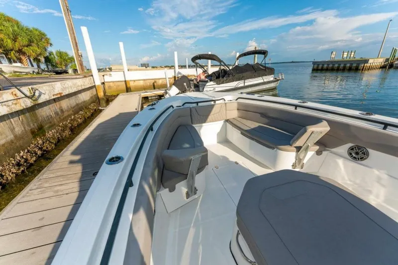 Slide: The Image of 2021 Wellcraft 302 Scarab boat docked, featuring spacious seating and sleek design. - 3