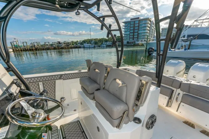 Slide: The Image of 2021 Wellcraft 302 Scarab boat interior with dual seats, docked in a marina. - 6