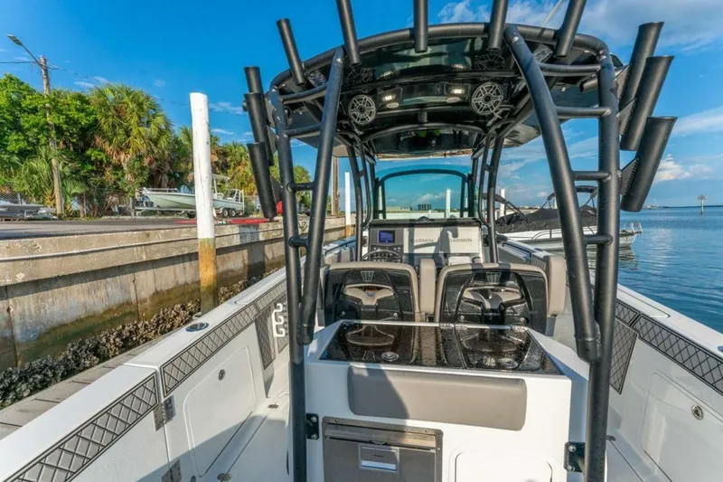 Slide: The Image of 2021 Wellcraft 302 Scarab boat docked by the water, showcasing sleek design and modern features. - 8