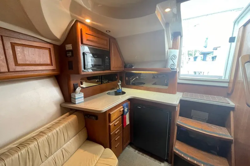 Slide: The Image of 1997 Luhrs 36 SX boat interior with kitchenette, microwave, and seating area. - 18