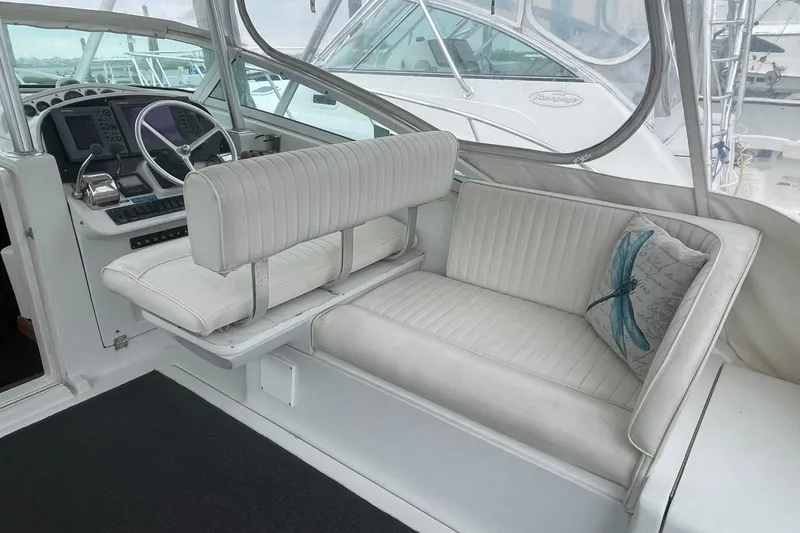 Slide: The Image of 1997 Luhrs 36 SX boat interior with white seating and dragonfly pillow. - 27