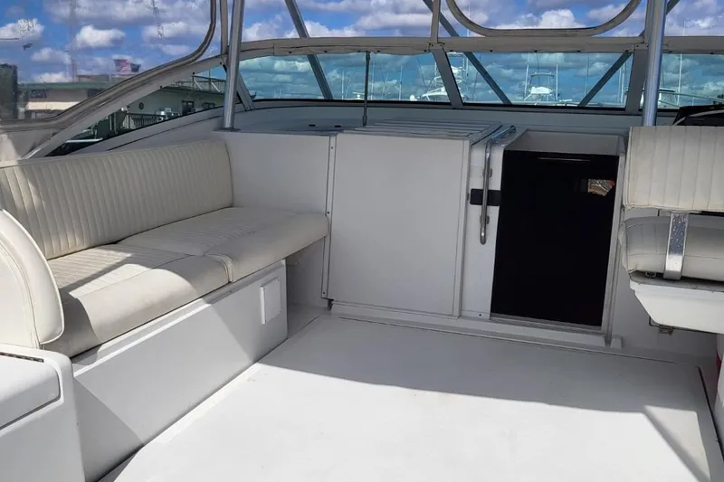 Slide: The Image of 1997 Luhrs 36 SX boat interior with white seating and clear skies. - 37