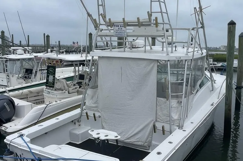 Slide: The Image of 1997 Luhrs 36 SX boat docked at marina, featuring fishing equipment and covered cockpit. - 9