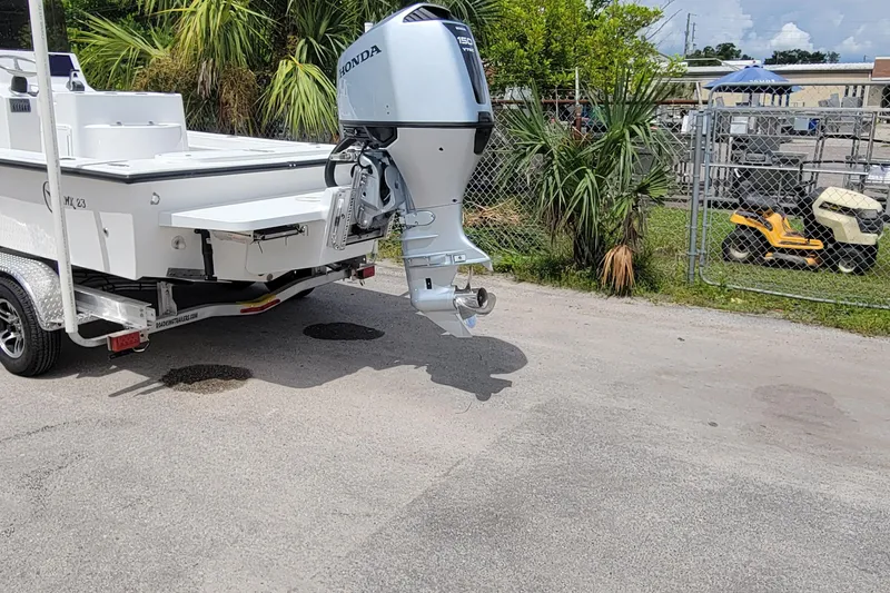 Slide: The Image of 2025 C-Hawk 23CC boat with Honda outboard motor on a trailer. - 2