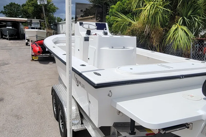 Slide: The Image of 2025 C-Hawk 23CC boat on trailer, parked outdoors near palm trees. - 3