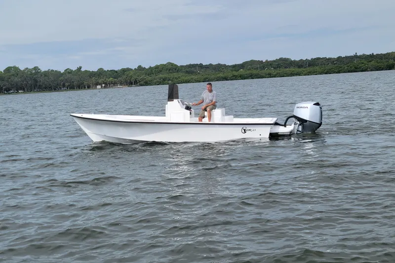 Slide: The Image of 2025 C-Hawk 23CC boat on calm water with Honda outboard motor. - 8