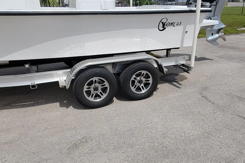 Slide: The Image of 2025 C-Hawk 23CC boat on trailer, featuring dual wheels and sleek design. - 4