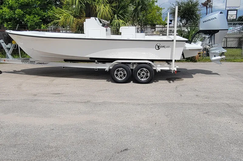 Slide: The Image of 2025 C-Hawk 23CC boat on trailer with Honda outboard motor, parked outdoors. - 5