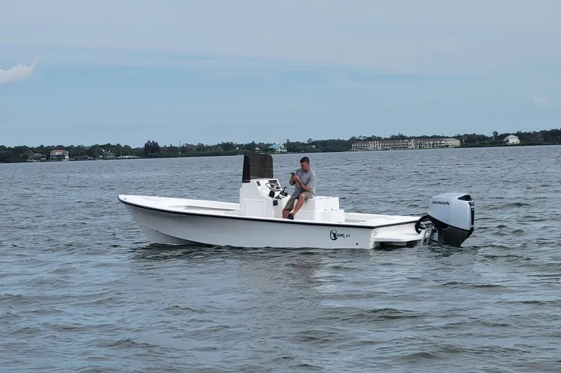 Slide: The Image of 2025 C-Hawk 23CC boat with Honda outboard motor on calm water. - 6