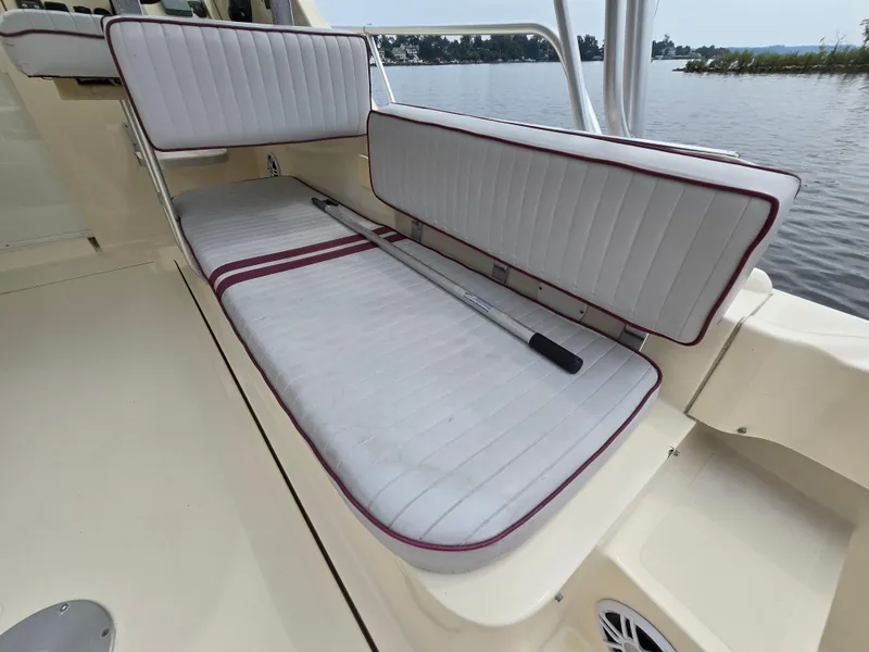 Slide: The Image of 2001 Mainship Pilot 30 Sedan boat interior with cushioned seating and a paddle, near water. - 11
