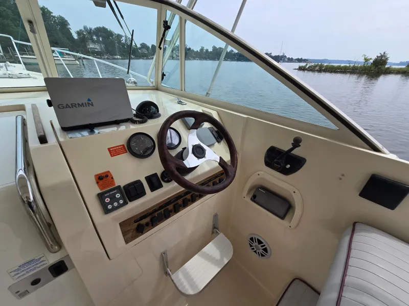 Slide: The Image of 2001 Mainship Pilot 30 Sedan helm with Garmin navigation, steering wheel, and control panel. - 14